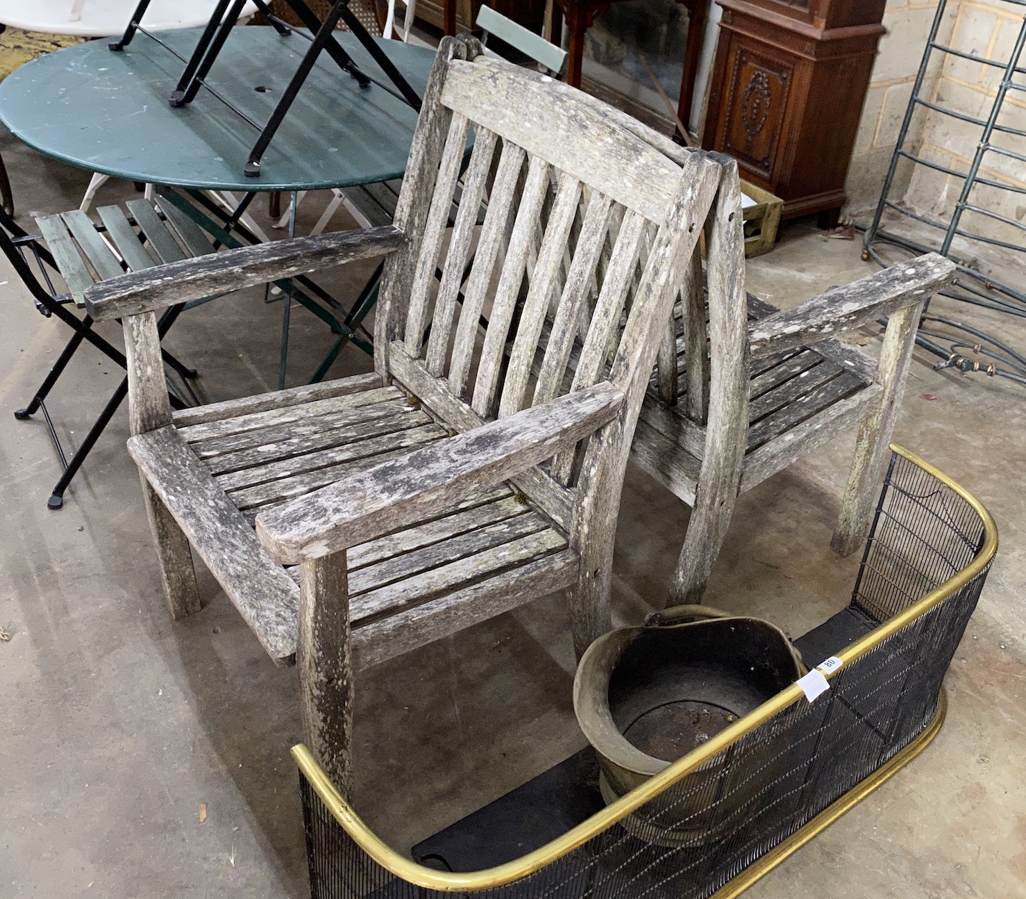 A pair of weathered teak garden elbow chairs, width 68cm, depth 52cm, height 95cm